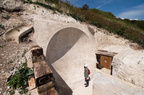 A woman stands by one of the First World War Sound Mirror listening devices at the Fan Bay Deep Shelter within the cliffs overlooking Dover England